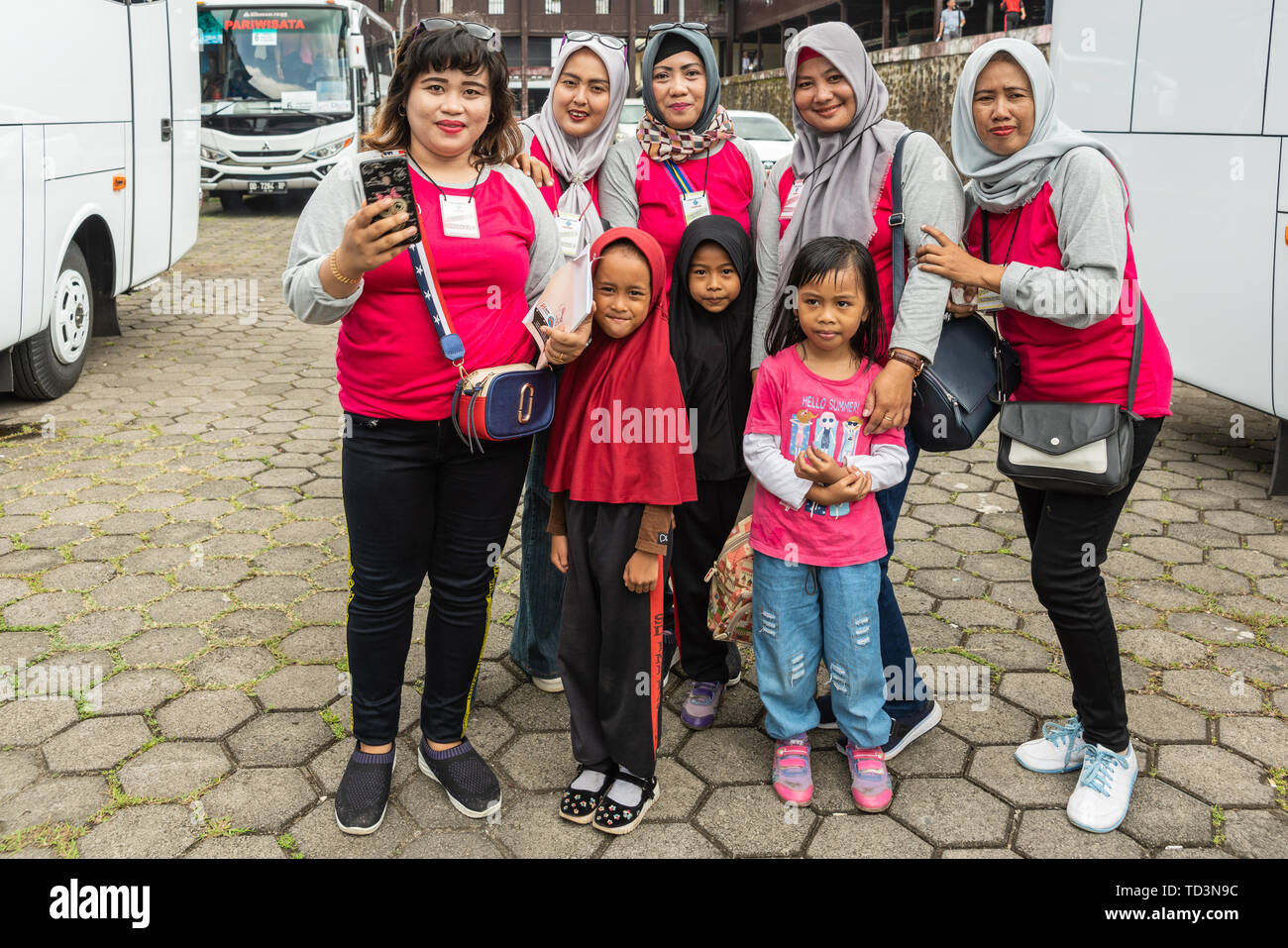 Makassar, Sulawesi, Indonésie - 28 Février 2019 Groupe : Muslima enseignants dans des chemises rouges avec trois petites filles. La plupart portent le hijab gris, l'un de l'enfant Banque D'Images