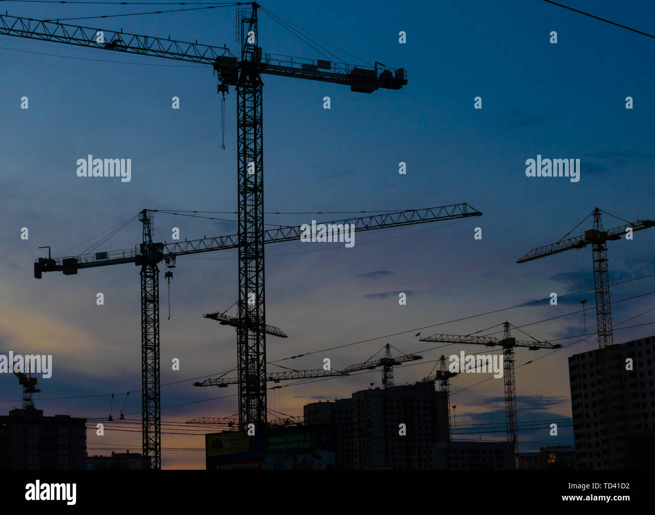 Groupe de grues de construction les bâtiments avec le Ciel de coucher du soleil sur l'arrière-plan Banque D'Images