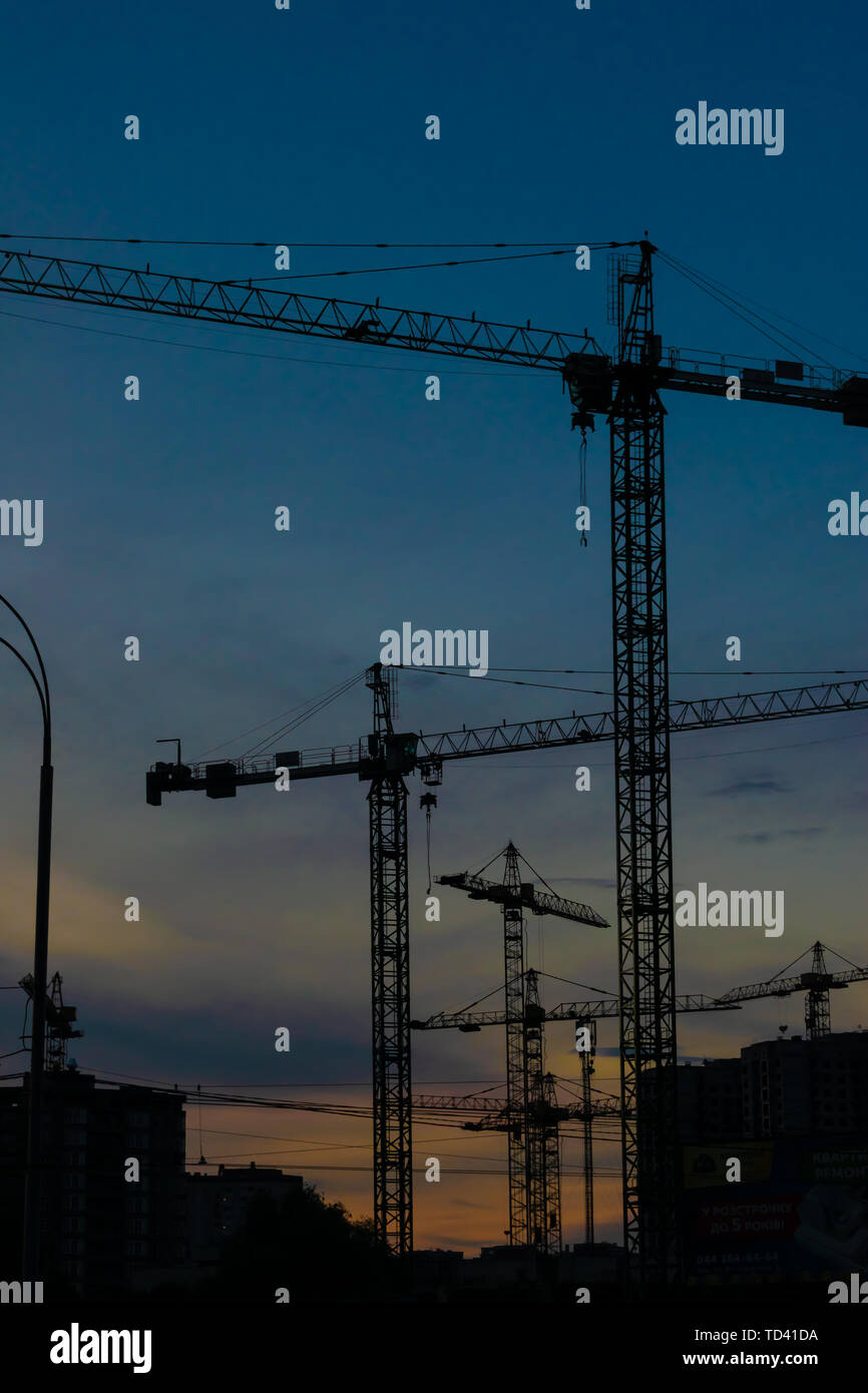 Groupe de grues de construction les bâtiments avec le Ciel de coucher du soleil sur l'arrière-plan Banque D'Images