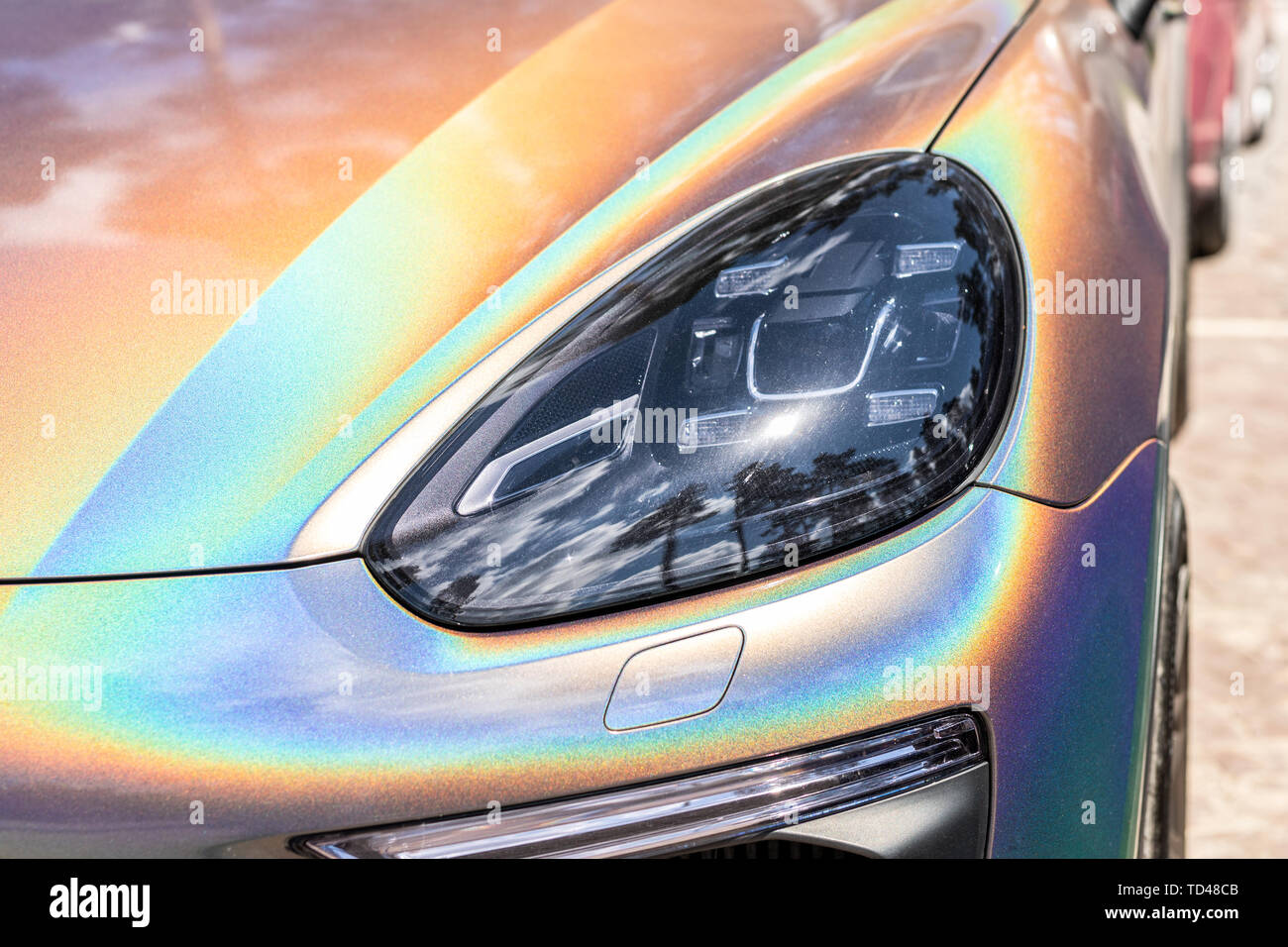 Close-up LED headlight cher avec pièce de voiture peinture iridescente exclusive. Véhicule couvert avec film caméléon dynamique Banque D'Images