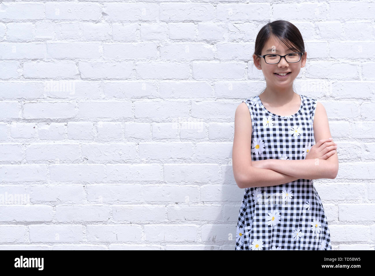 Portrait de jeune fille asiatique contre le mur en brique blanche Banque D'Images