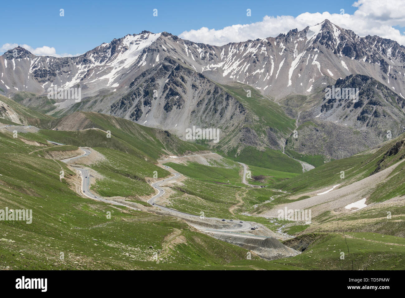 Les prairies alpines le long de la G217 Duku sous l'autoroute l'été, ciel bleu et nuages blancs dans le Xinjiang, Chine Banque D'Images