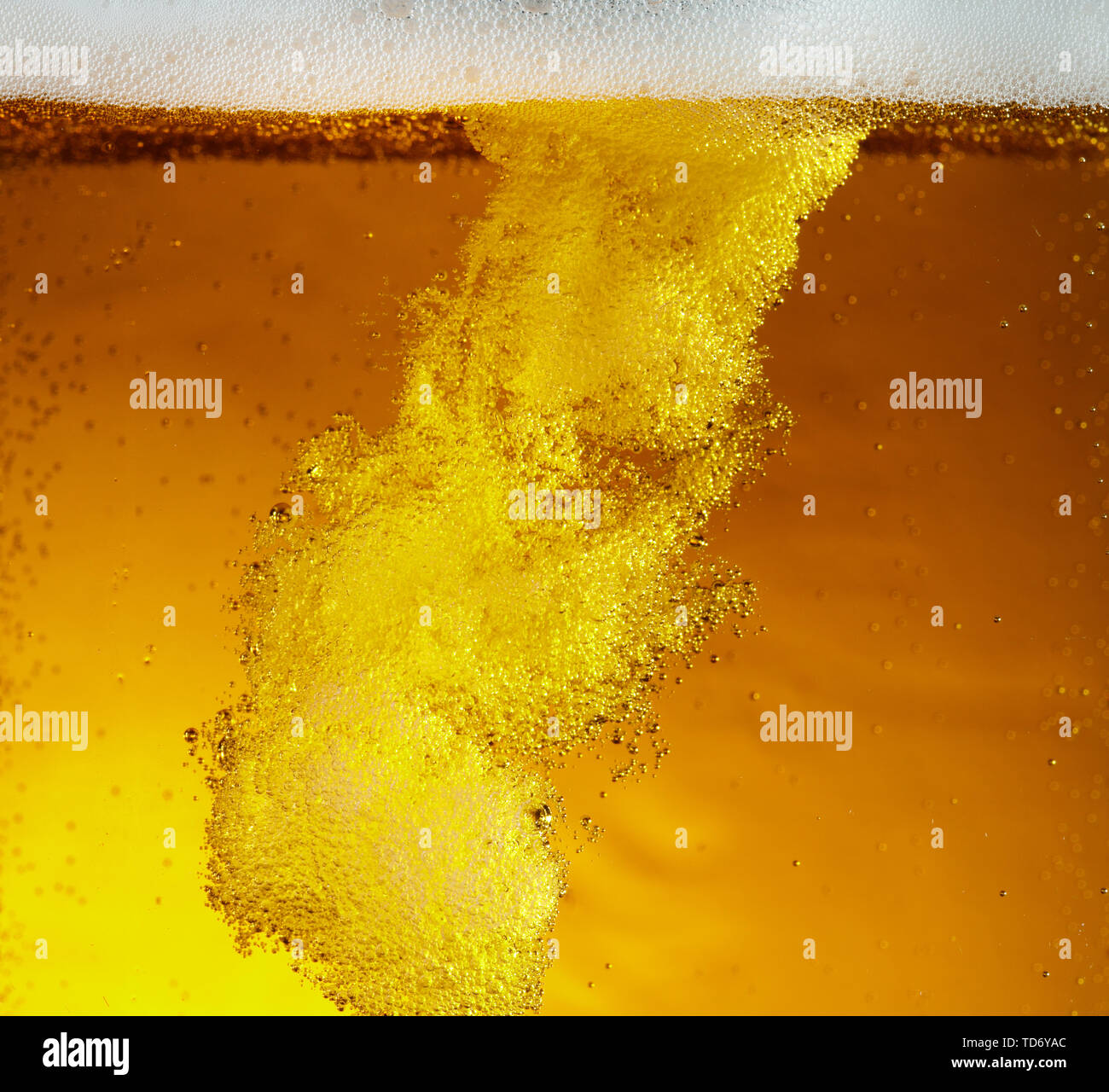 Vue rapprochée de bulles flottantes en bière de couleur d'or léger arrière-plan. La texture de l'été de refroidissement verre filtré avec mousse et macro fizz sur le mur de verre. L'effervescence ou flottant jusqu'au-dessus de la surface. Banque D'Images