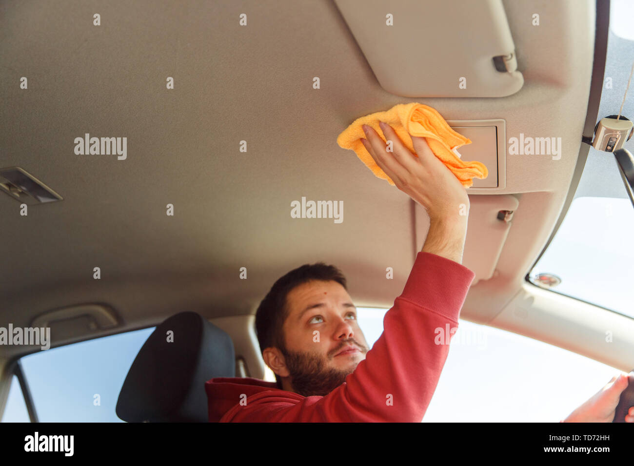Photo sur le côté de l'homme orange avec salon de voiture lavage Chiffon Banque D'Images