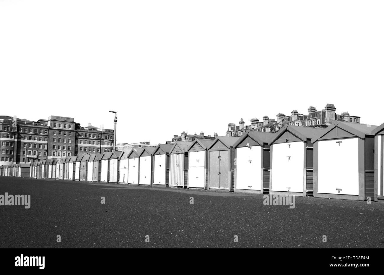 Noir et blanc la photographie de paysage avec une rangée de cabanes de plage de Hove, Brighton, Royaume-Uni. Contraste élevé. Banque D'Images
