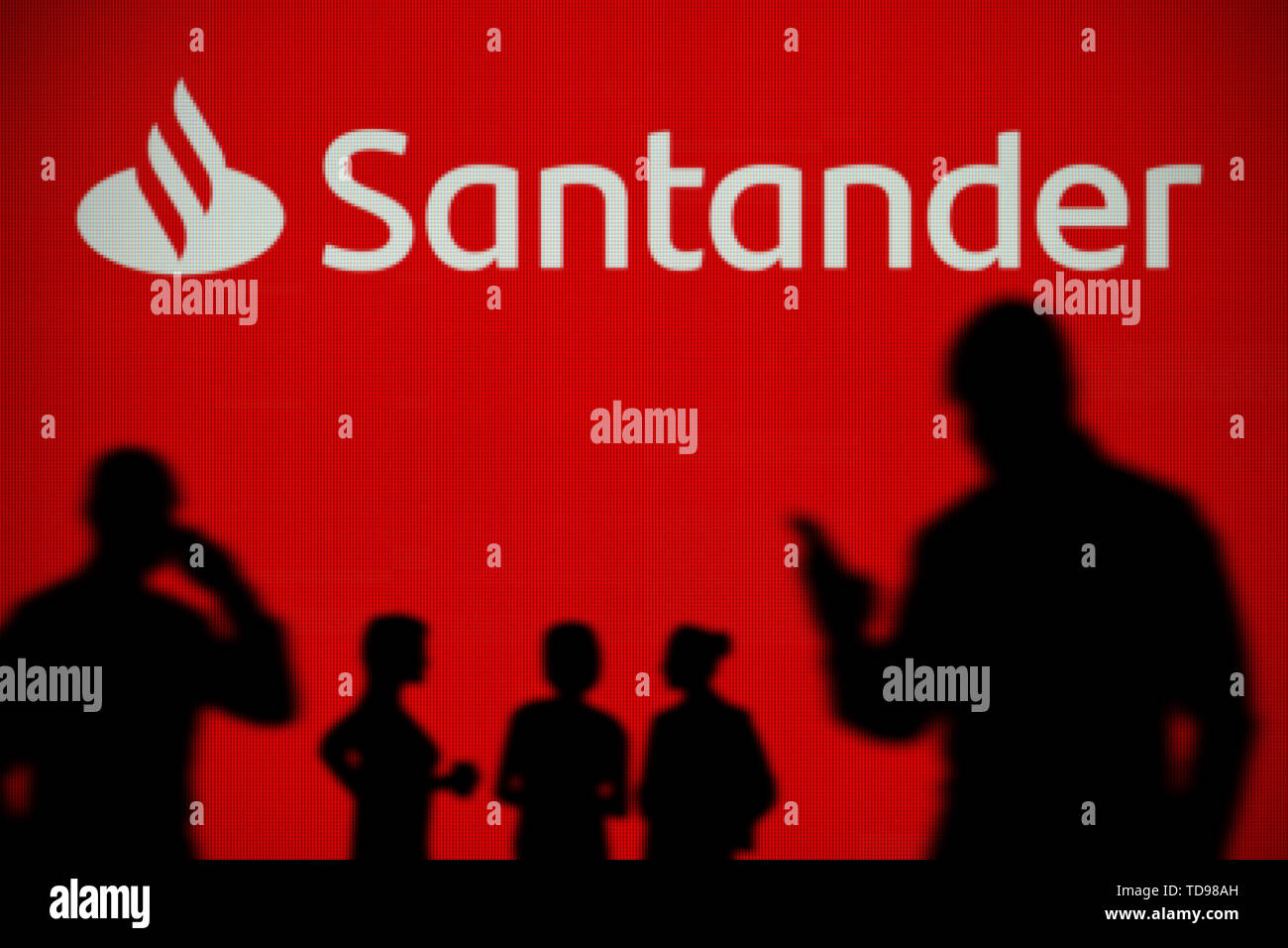 Le logo de la Banque Santander est vu sur un écran LED à l'arrière-plan tandis qu'une personne utilise la silhouette d'un smartphone dans l'avant-plan (usage éditorial uniquement) Banque D'Images Le logo de la Banque Santander est vu sur un écran LED à l'arrière-plan tandis qu'une personne utilise la silhouette d'un smartphone dans l'avant-plan (usage éditorial uniquement) Banque D'Images