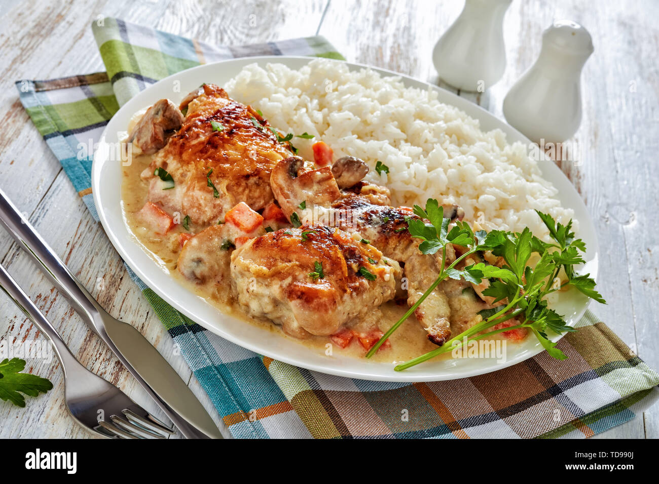Compotée de poulet à la crème et sauce au vin blanc, champignons et légumes et servi avec du riz dans une assiette avec du riz - Fricassée de poulet, fre classique Banque D'Images