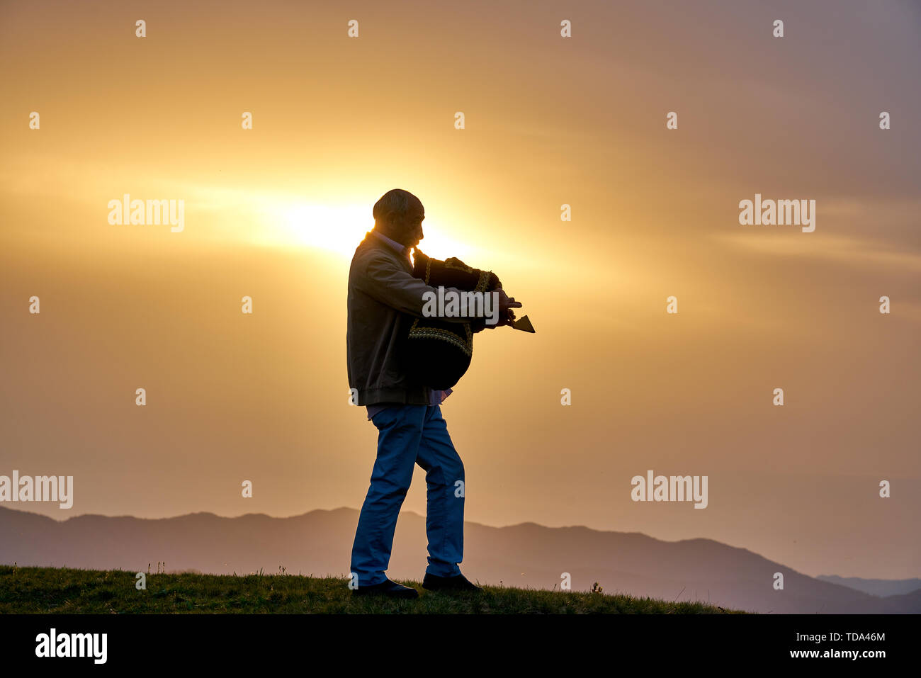 Homme jouant locales (traditionnel turc - Karadeniz - Laz) instrument de musique cornemuse Tulum au coucher du soleil, au Plateau Pokut, Rize, Turquie Banque D'Images