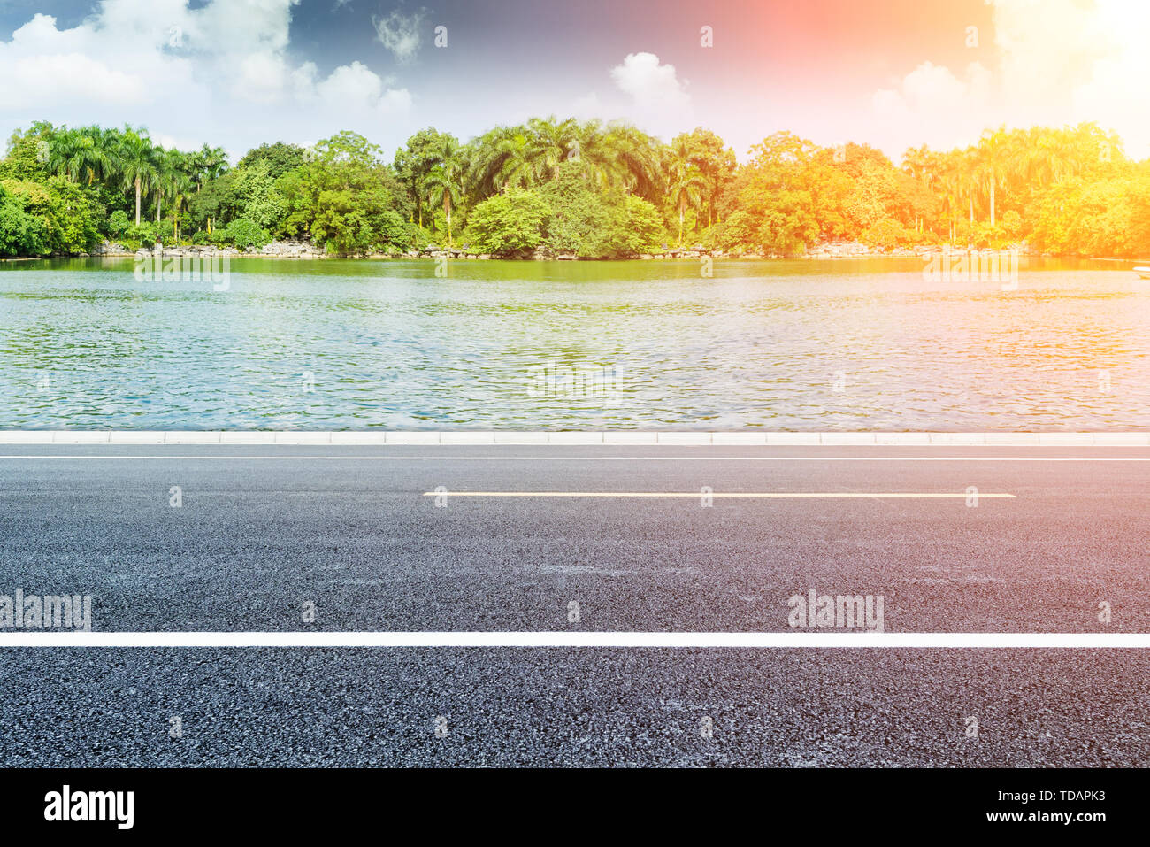 Ciel bleu et nuages blancs, Lake Shore paysage avec un revêtement en asphalte, la publicité automobile historique des matériaux routiers Banque D'Images