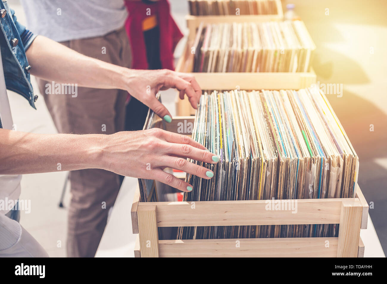Femme choisissant vinyl records en vente. Les mains de femmes élégantes dans le cadre. Banque D'Images