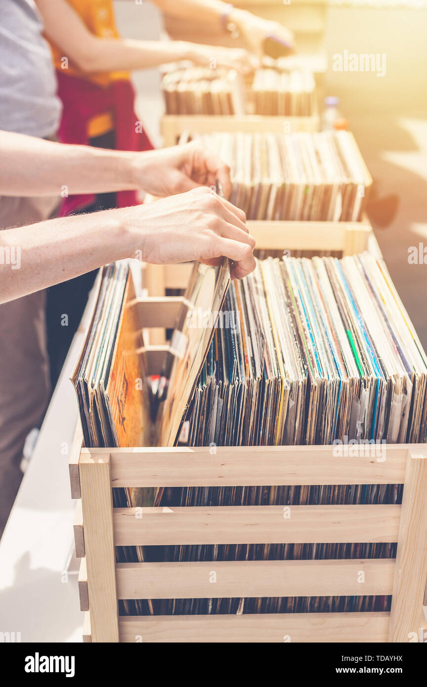 Femme choisissant vinyl records en vente. Les mains de femmes élégantes dans le cadre. Shot verticale Banque D'Images
