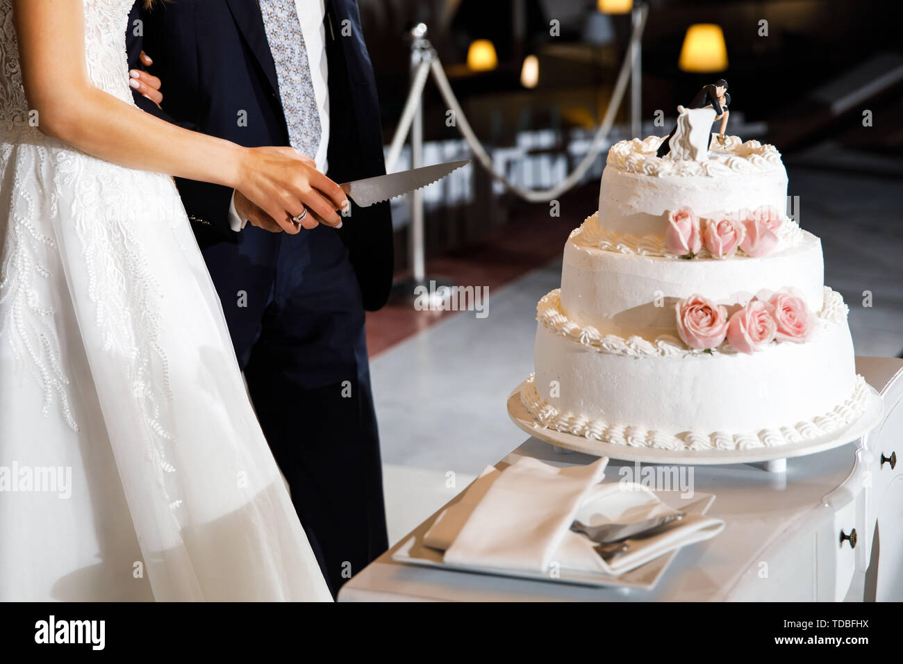 Les mariés se préparent à couper le gâteau de mariage. Banque D'Images