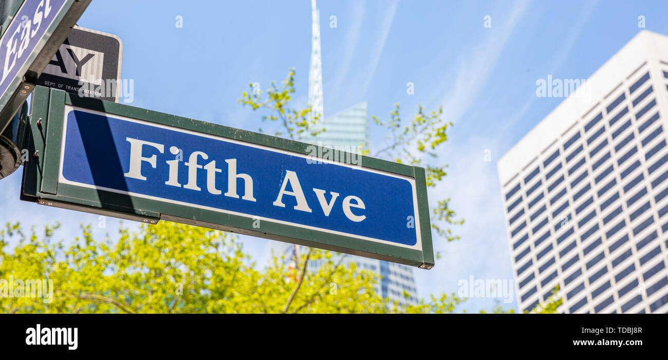 Fifth Ave street sign, Manhattan New York downtown. Panneau bleu sur la façade des bâtiments flou et fond de ciel bleu, Banque D'Images