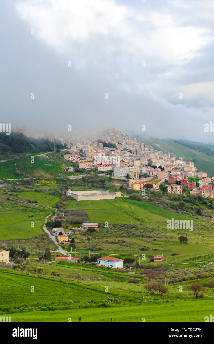 Photo verticale du pittoresque village sicilien Gangi en Italie capturé dans le brouillard. La petite ville historique est entouré par un paysage verdoyant et est situé sur le sommet des collines. Campagne italienne. Banque D'Images