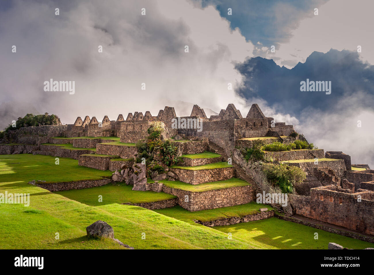 Vue mystique sur le Machu Picchu ville ruines couvertes de brouillard avec les rayons du soleil en passant par les nuages. Ville sacrée de l'Inca pendant le lever du soleil. Banque D'Images