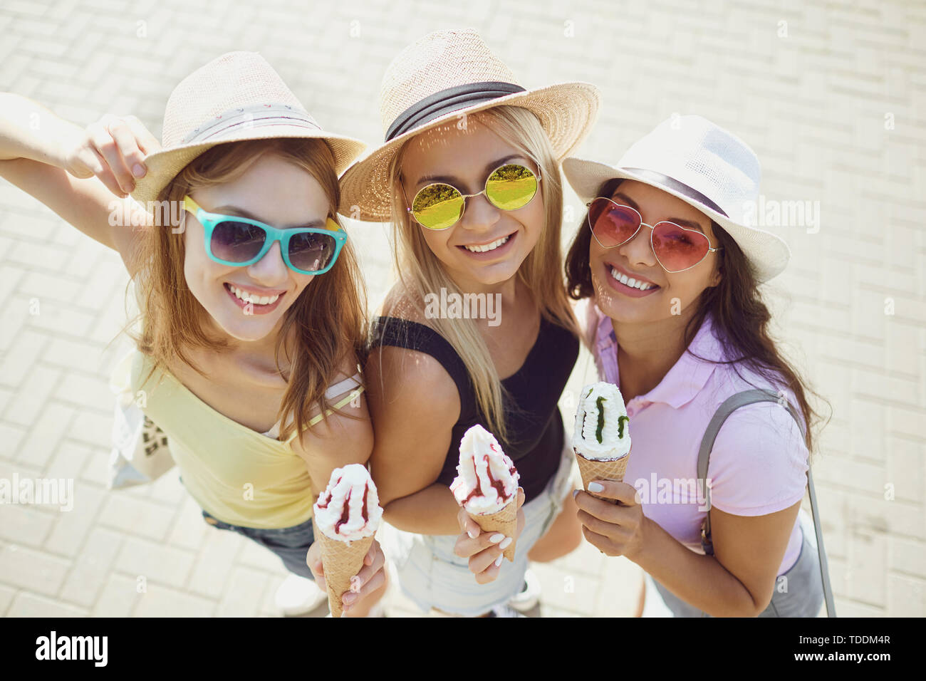 Les amies la consommation de crème glacée dans le parc en été. Banque D'Images