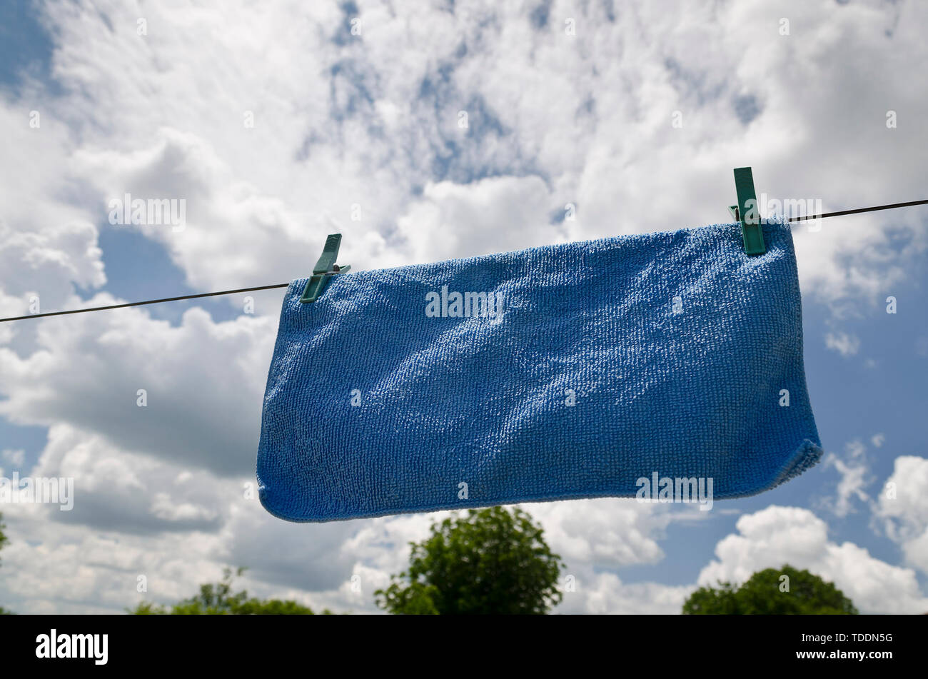 Vêtements peg sur une serviette bleue et lave-line against a blue sky Banque D'Images