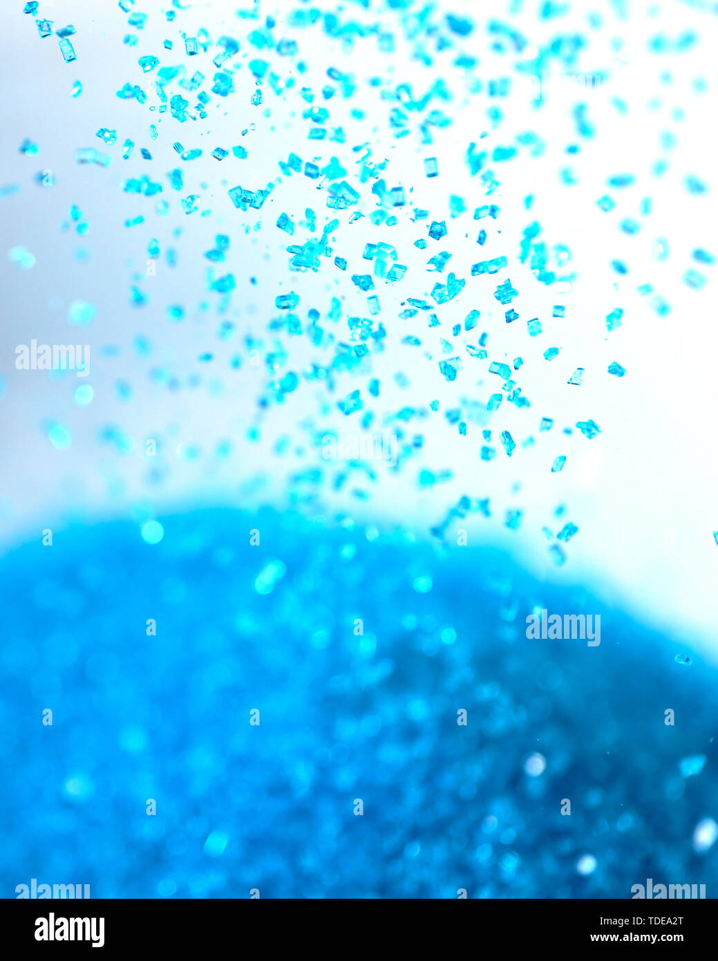 Libre de sucre coloré bleu clair arrose de tomber dans un tas de plus en plus Banque D'Images