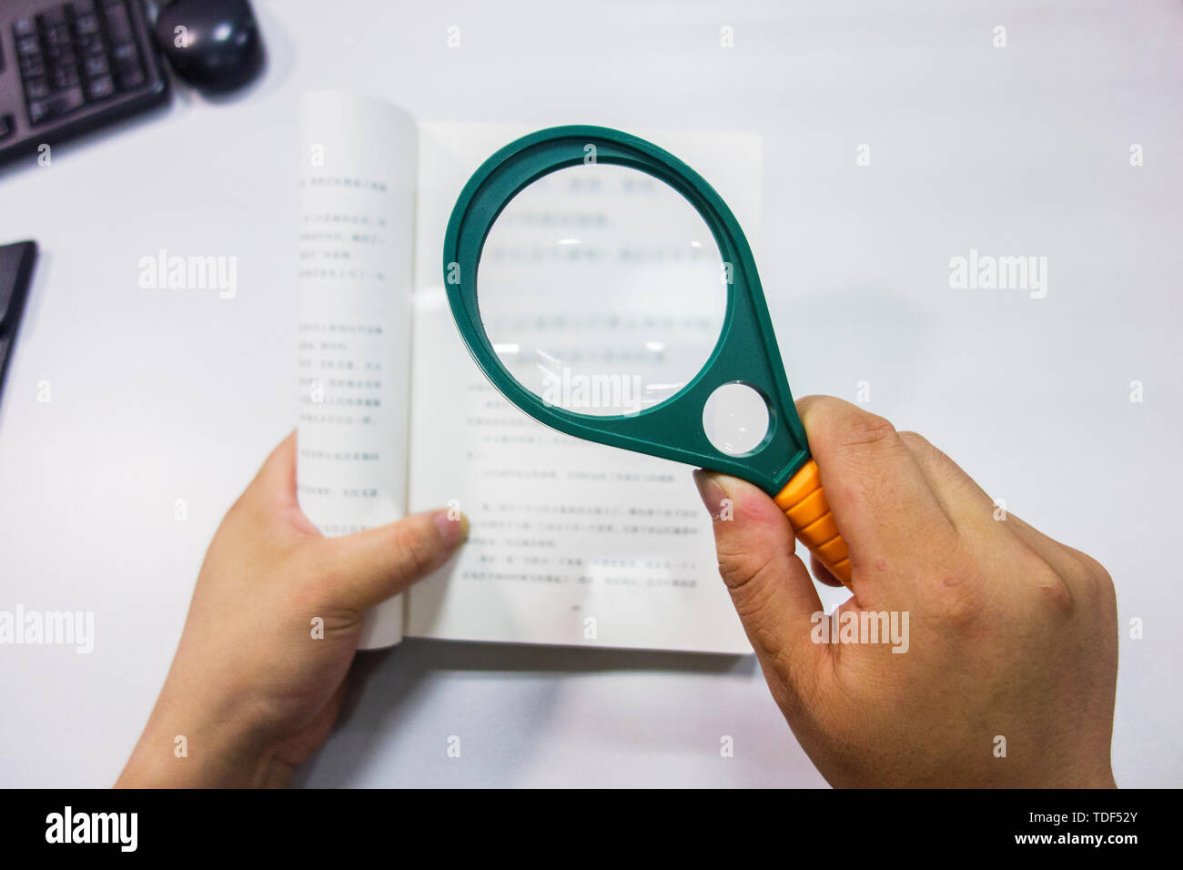 Une photo de la lecture d'un livre avec une loupe. Banque D'Images