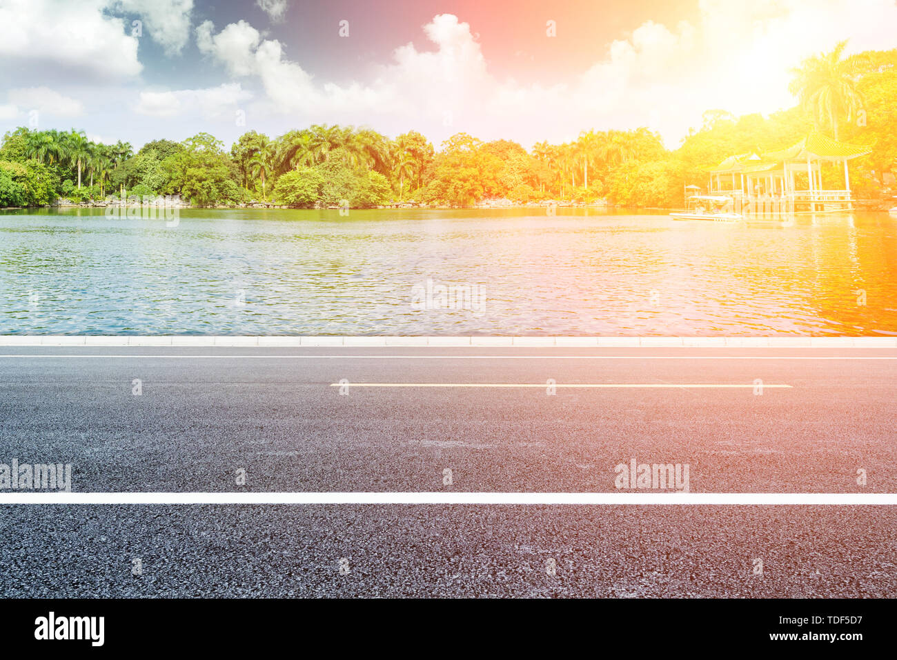 Ciel bleu et nuages blancs, Lake Shore paysage avec un revêtement en asphalte, la publicité automobile historique des matériaux routiers Banque D'Images