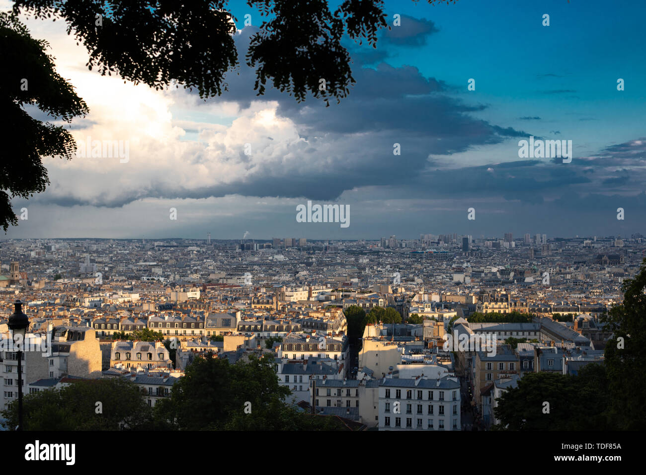 Vue panoramique de Paris illuminé par le soleil après un orage. Vue depuis la colline de Montmartre de Paris dans la soirée sous contraste ciel. Banque D'Images