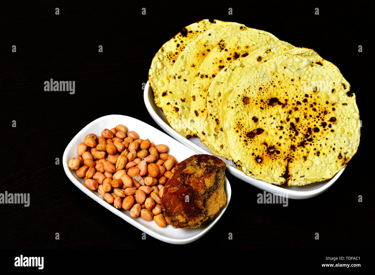Un snack-indienne papad rôti entier avec des arachides et jagré dans une assiette. Banque D'Images