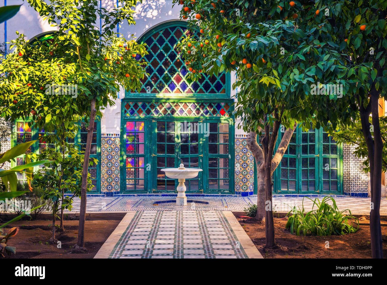 Petite fontaine blanche parmi les orangers du jardin Majorelle, Marrakech, Maroc Banque D'Images