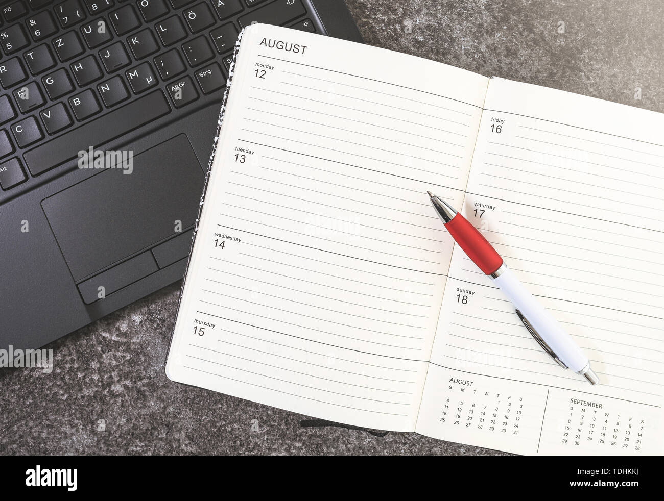Vue du dessus de l'ouverture de calendrier ou un planificateur et un stylo sur un ordinateur portable Banque D'Images