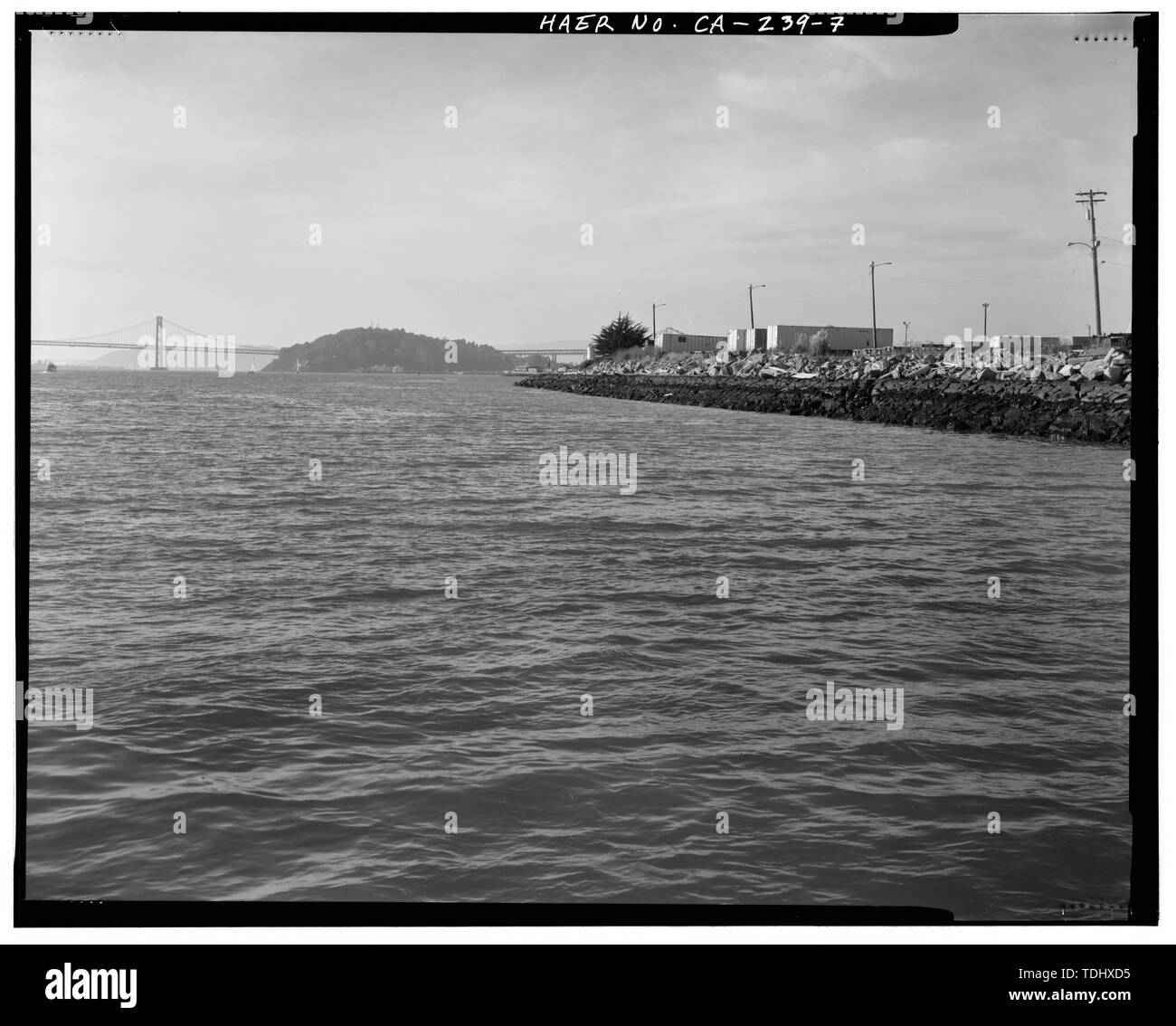 Aperçu de l'EXTRÉMITÉ OUEST DE L'AMÉRIQUE DU MUR D'ENTRAÎNEMENT, À PARTIR DE L'EAU, avec l'île de Yerba Buena ET LE SAN FRANCISCO-Oakland Bay Bridge DANS LA DISTANCE. Vue DE NORD-OUEST. - Le port d'Oakland murs formation, la bouche de canal à Port intérieur, Oakland, Alameda County, CA Banque D'Images