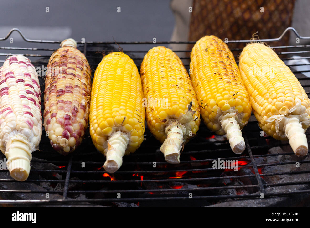 Des épis de maïs grillés sur le poêle chaud avec du charbon de bois Photo  Stock - Alamy