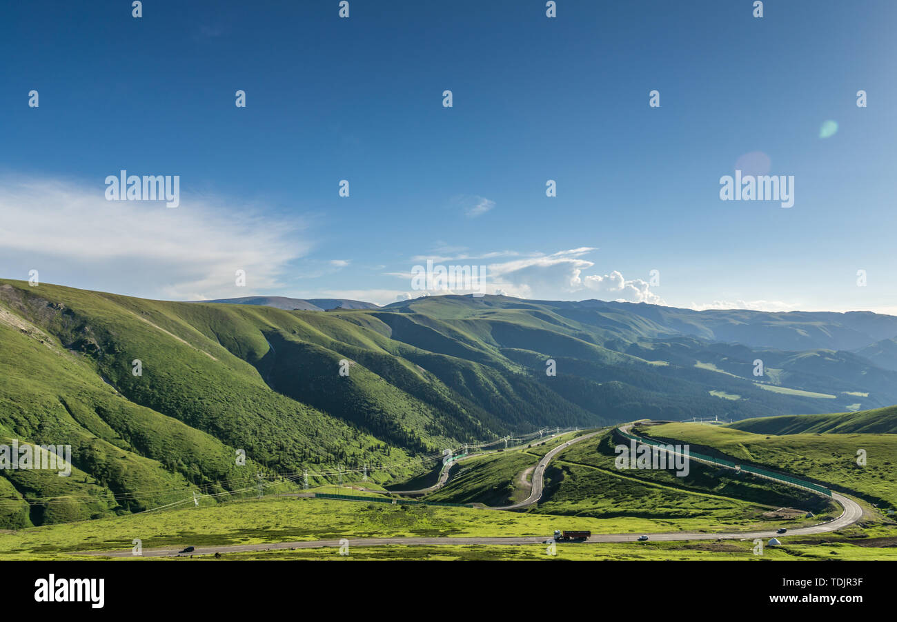Les prairies alpines le long de la G217 Duku sous l'autoroute l'été, ciel bleu et nuages blancs dans le Xinjiang, Chine Banque D'Images