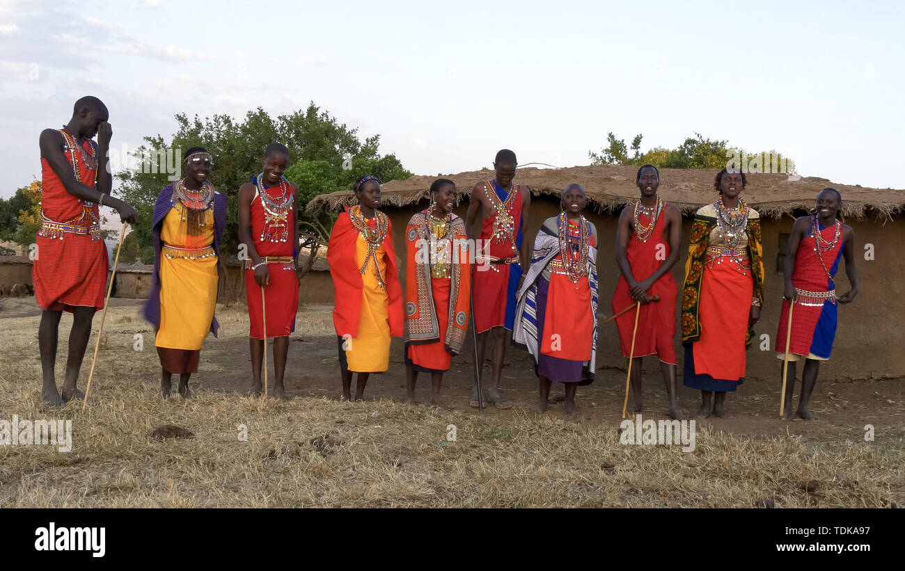 Large vue d'un groupe de dix hommes et femmes maasai chanter par enkereri village près de Maasai Mara au Kenya Banque D'Images