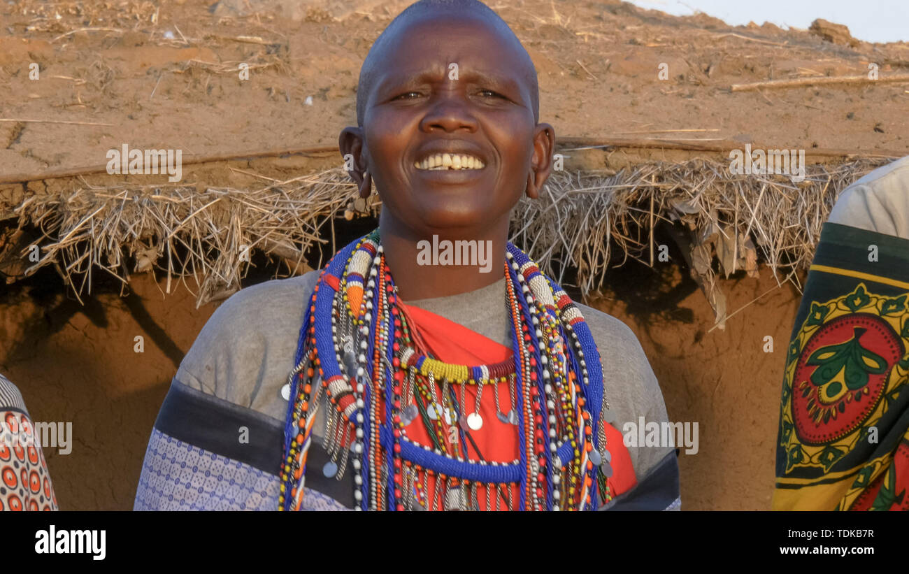 Close up d'un masaï portant des vêtements gris et des bijoux traditionnels chantant dans un village près de Masai Mara au Kenya Banque D'Images