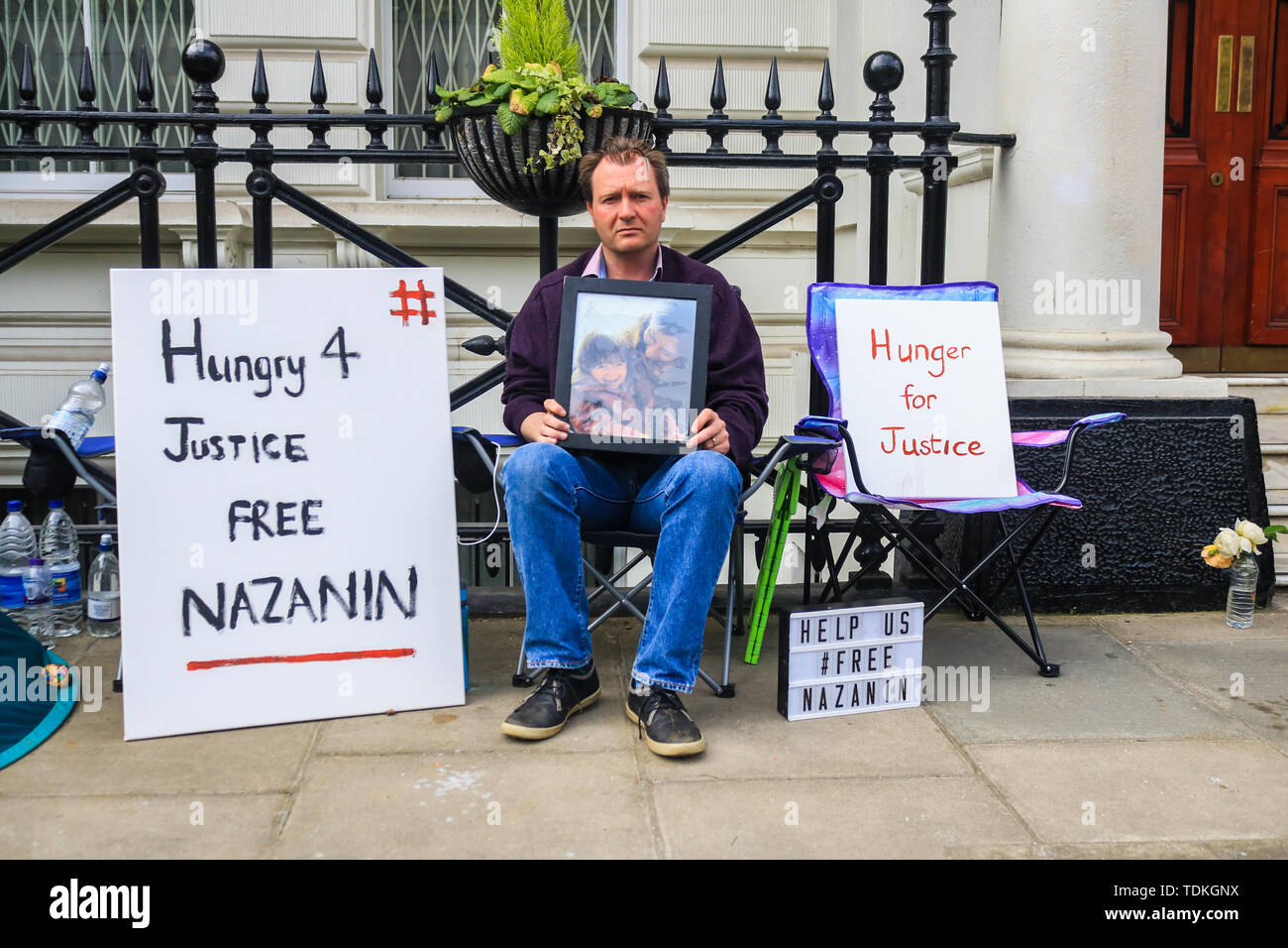 Londres, Royaume-Uni. 17 Juin, 2019. Richard Ratcliffe tenant une photo de Nazanin et leur fille Gabriella organise une grève de la faim devant l'ambassade d'Iran à Londres pour protester contre la poursuite de l'emprisonnement de son épouse Nazanin Zaghari Ratcliffe qui a eu lieu sur de prétendues accusations d'espionnage l'Iran depuis 2016 à une peine de prison de cinq ans dont elle nie Crédit : amer ghazzal/Alamy Live News Banque D'Images