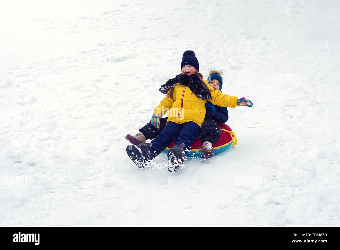 Heureux les enfants luge tube. frère et soeur jouent ensemble en hiver. Les enfants dévaler la colline. Les enfants rire et émotions. Banque D'Images