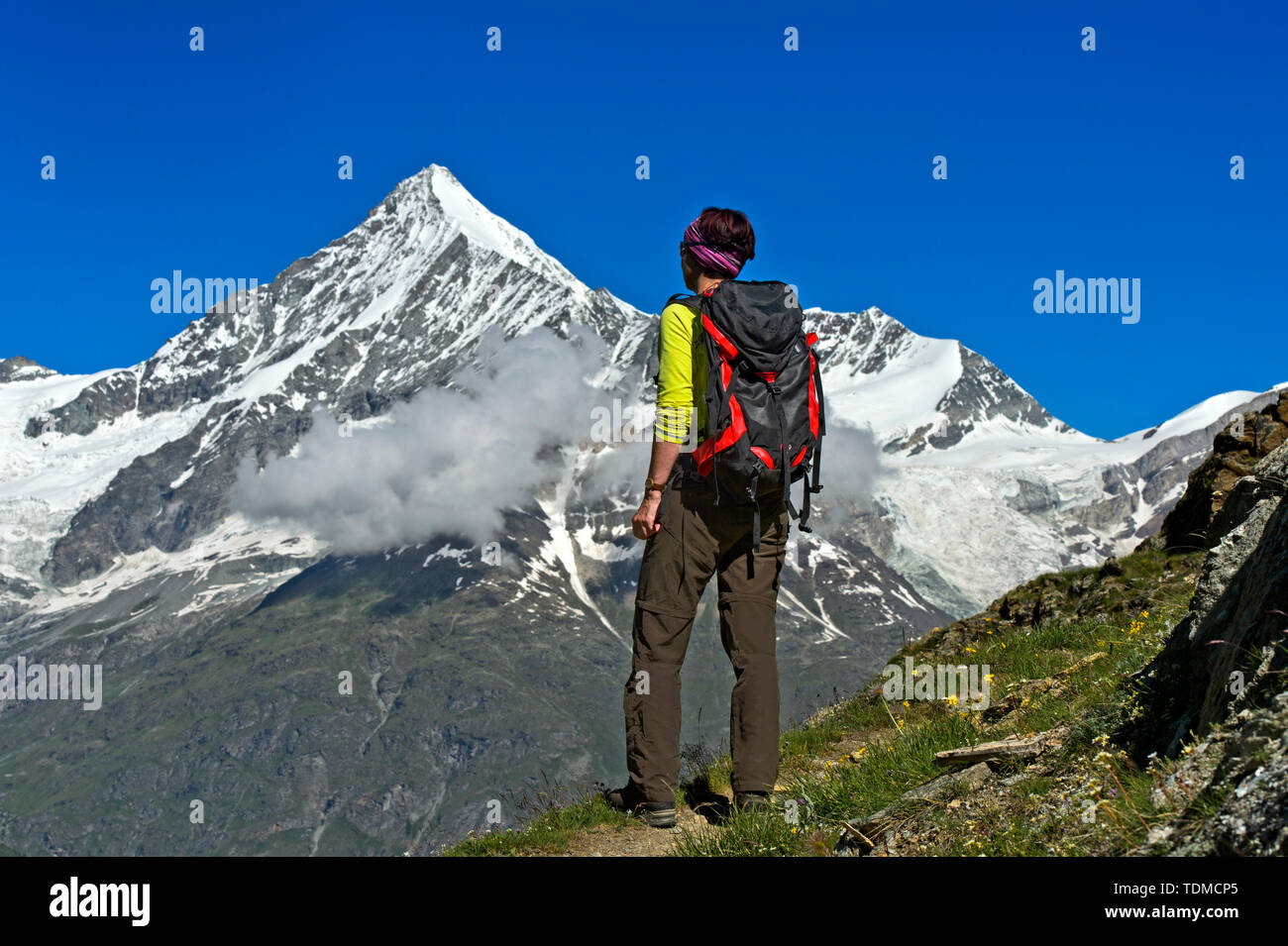 Femme avec sac à dos à la recherche au-dessus de la crête Weisshorn vallée Mattertal, Täschalp, Valais, Suisse Banque D'Images