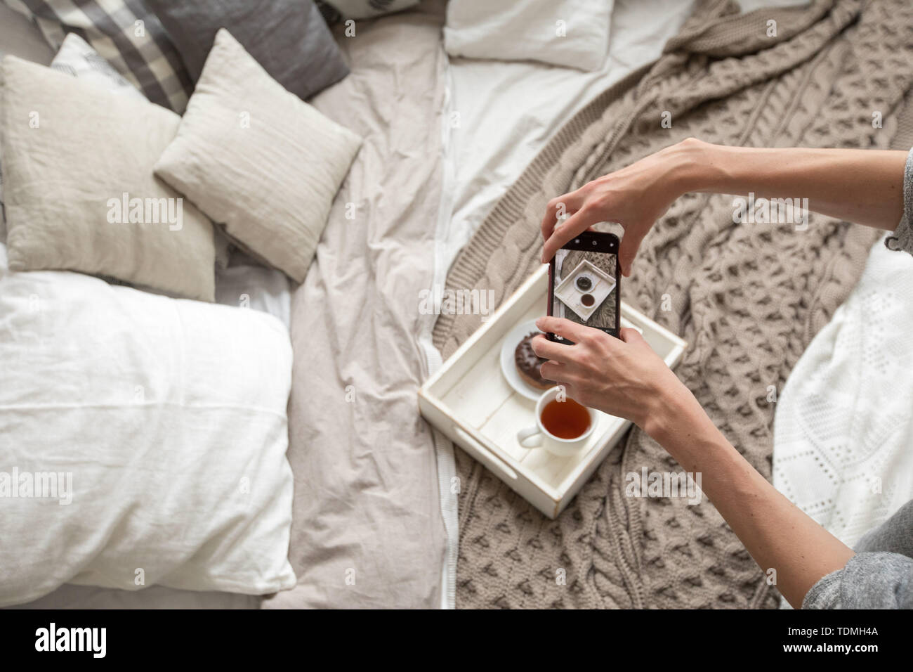 Woman taking shot du bac avec la nourriture on bed Banque D'Images