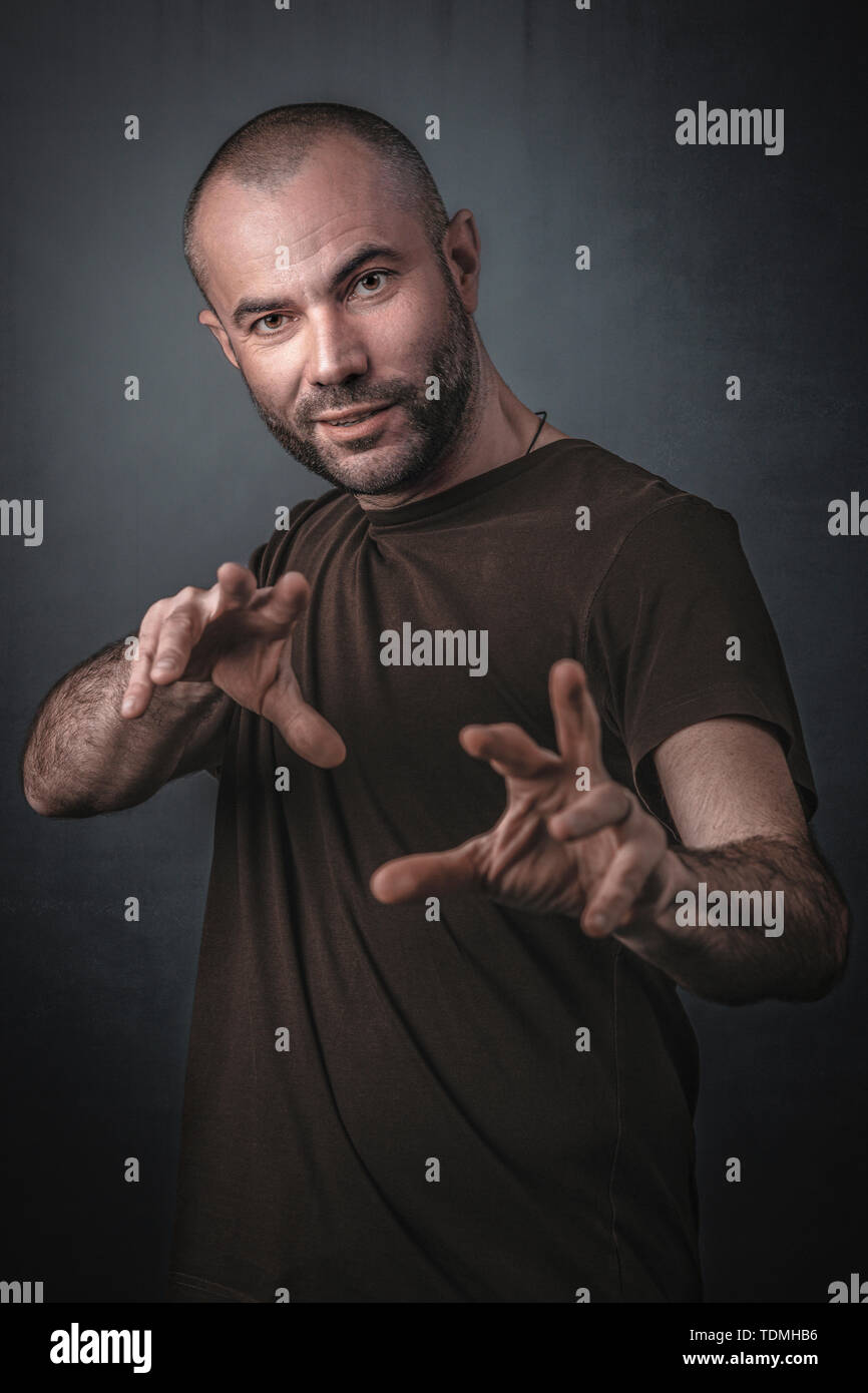 Portrait d'homme avec mains tendues en avant en geste magique.Studio Shot Banque D'Images