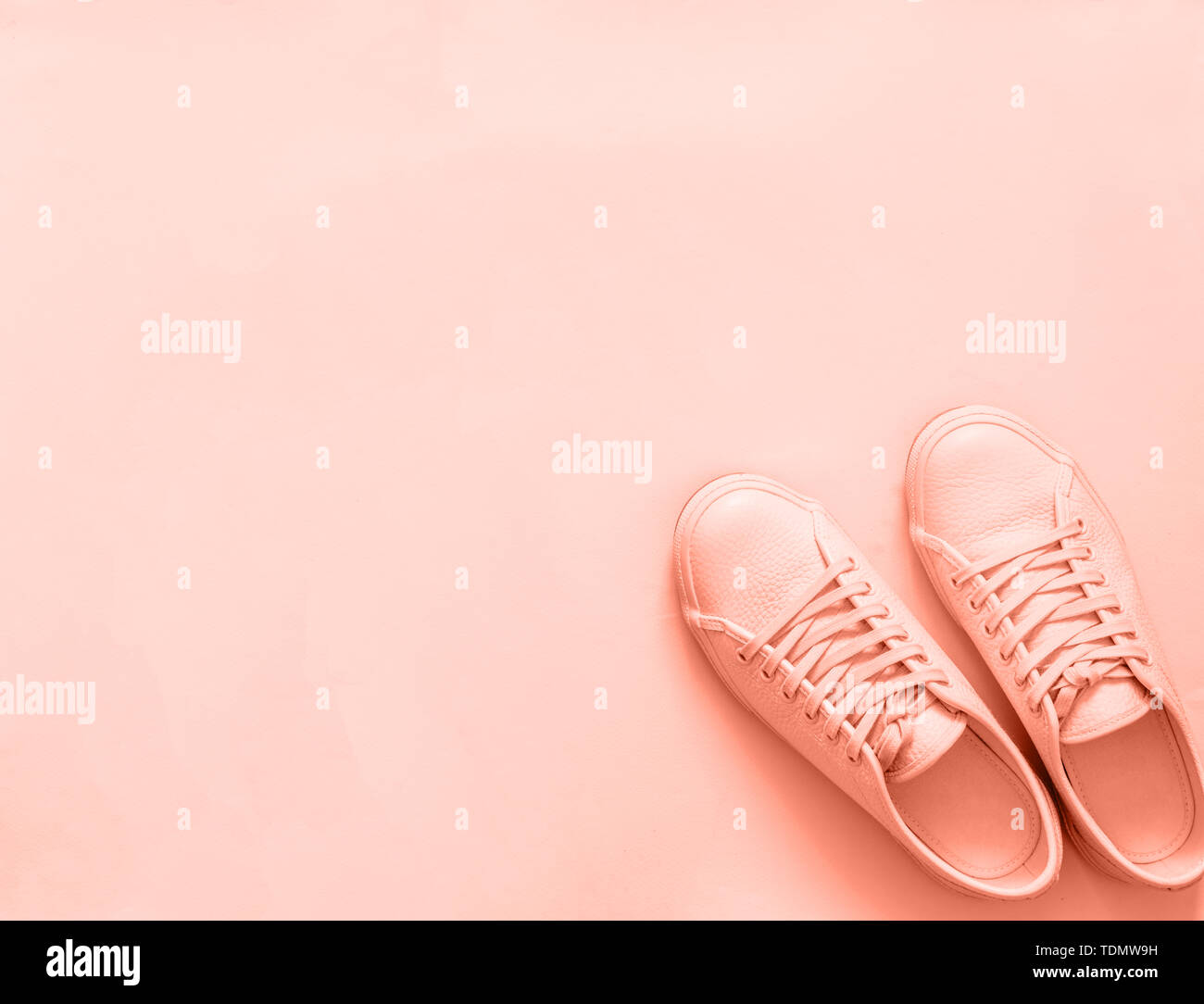 Sneakers en cuir rose sur fond rose ou pêche. Paire de chaussures ou des chaussures de sport rose avec copie espace pour texte ou dessin. Nouveau coup de frais généraux sneakers rose monochrome,.Vue de dessus ou de mise à plat Banque D'Images