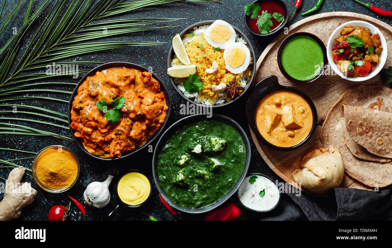 Des plats de cuisine indienne : tikka masala, paneer, samosa, chapati, chutney, épices. La nourriture indienne sur fond sombre. Assortiment repas indien haut afficher ou mettre à plat. L'espace de copie pour