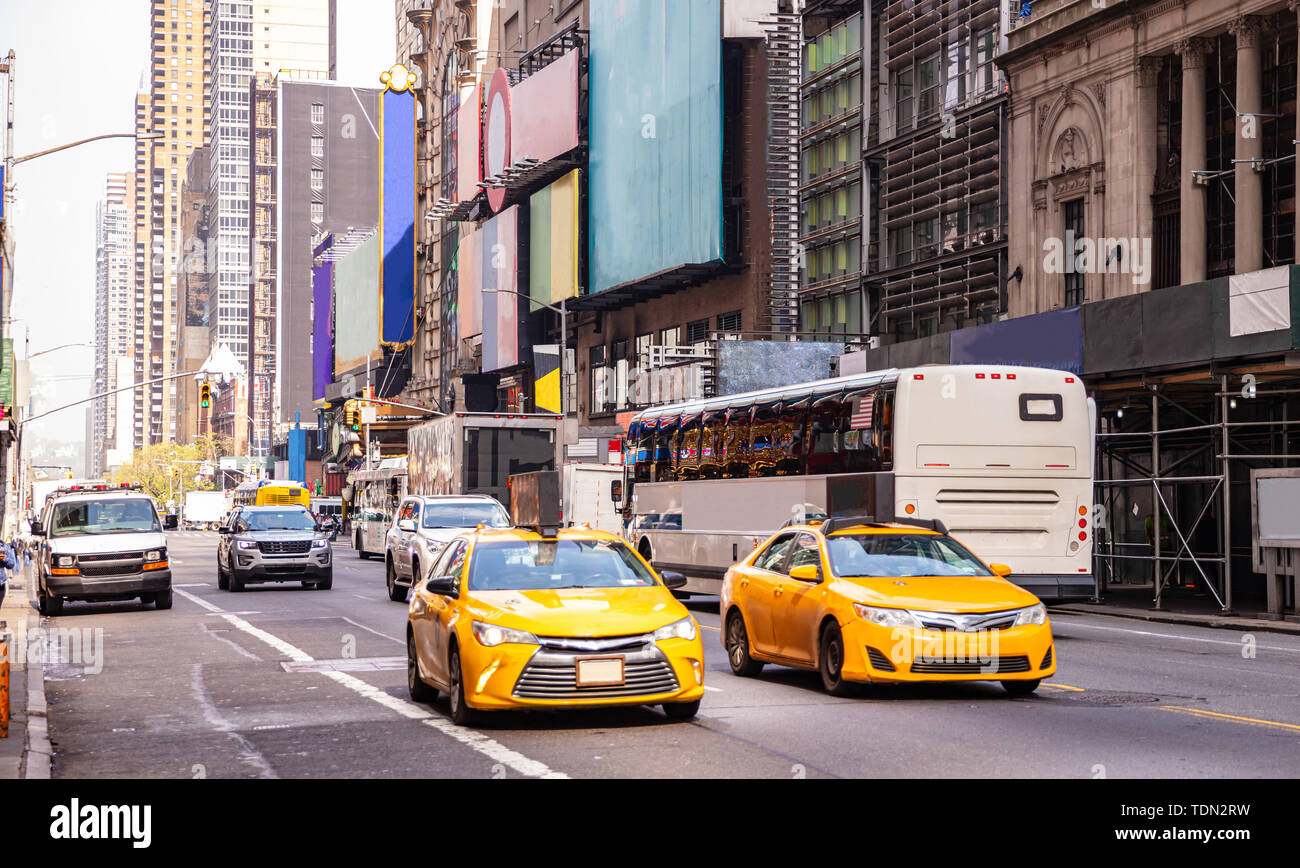 New York, Manhattan rues. Gratte-ciel, des signes colorés et d'annonces, voitures et taxis Banque D'Images