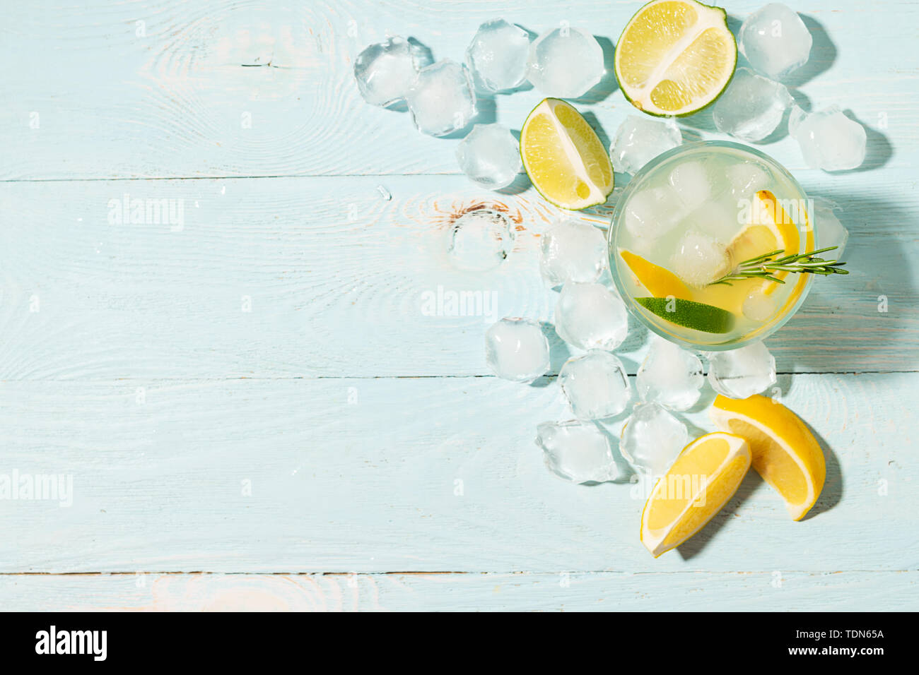 Un verre de limonade citron et lime en verres transparents fond bleu plein soleil. Cocktail d'été ou mojito. Banque D'Images