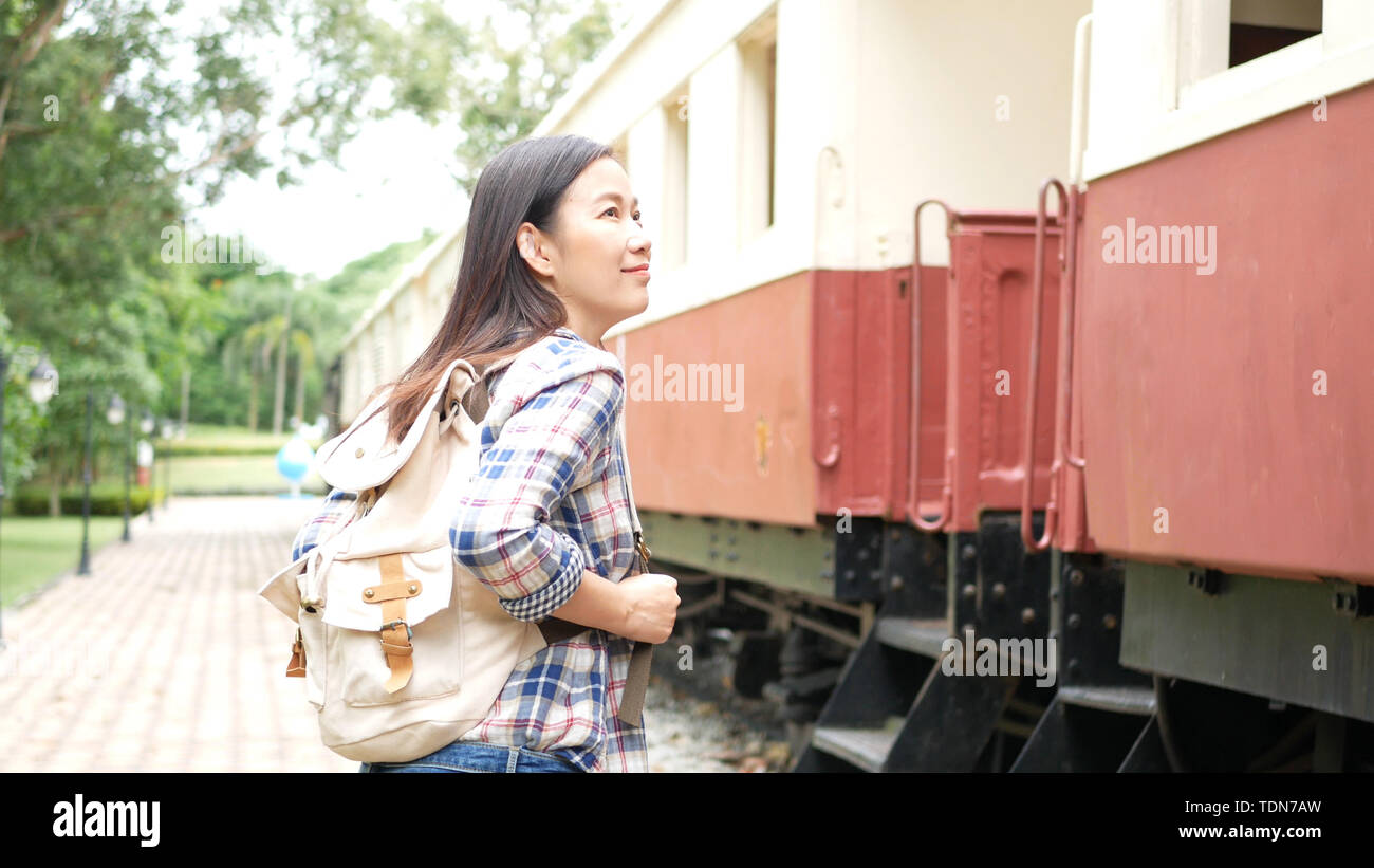 Happy Asian'Femme avec sac à dos de marche de la gare ferroviaire, à commencer à voyager seul. transport en Asie par vintage train. Les touristes tra Banque D'Images