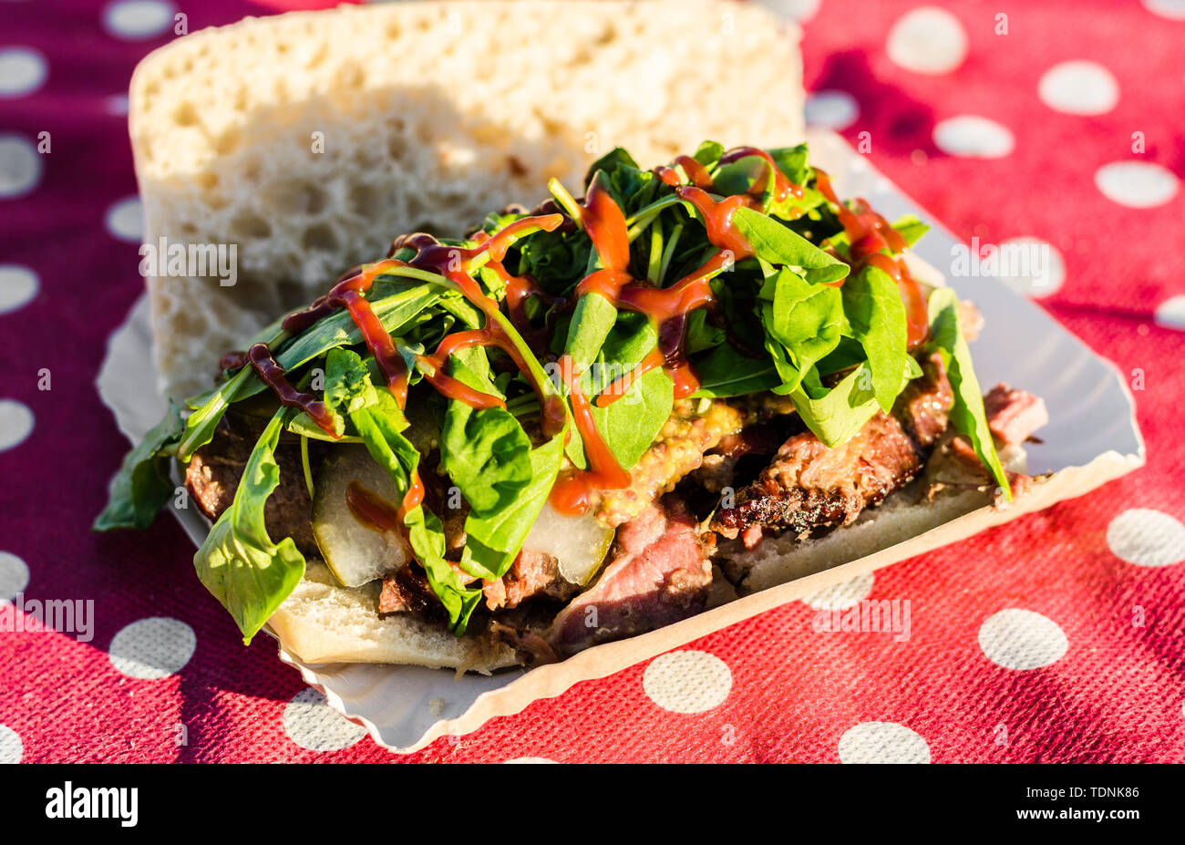 Avec Sandwich boeuf fumé cuit lentement et la sauce barbecue à un marché de l'alimentation de rue Banque D'Images