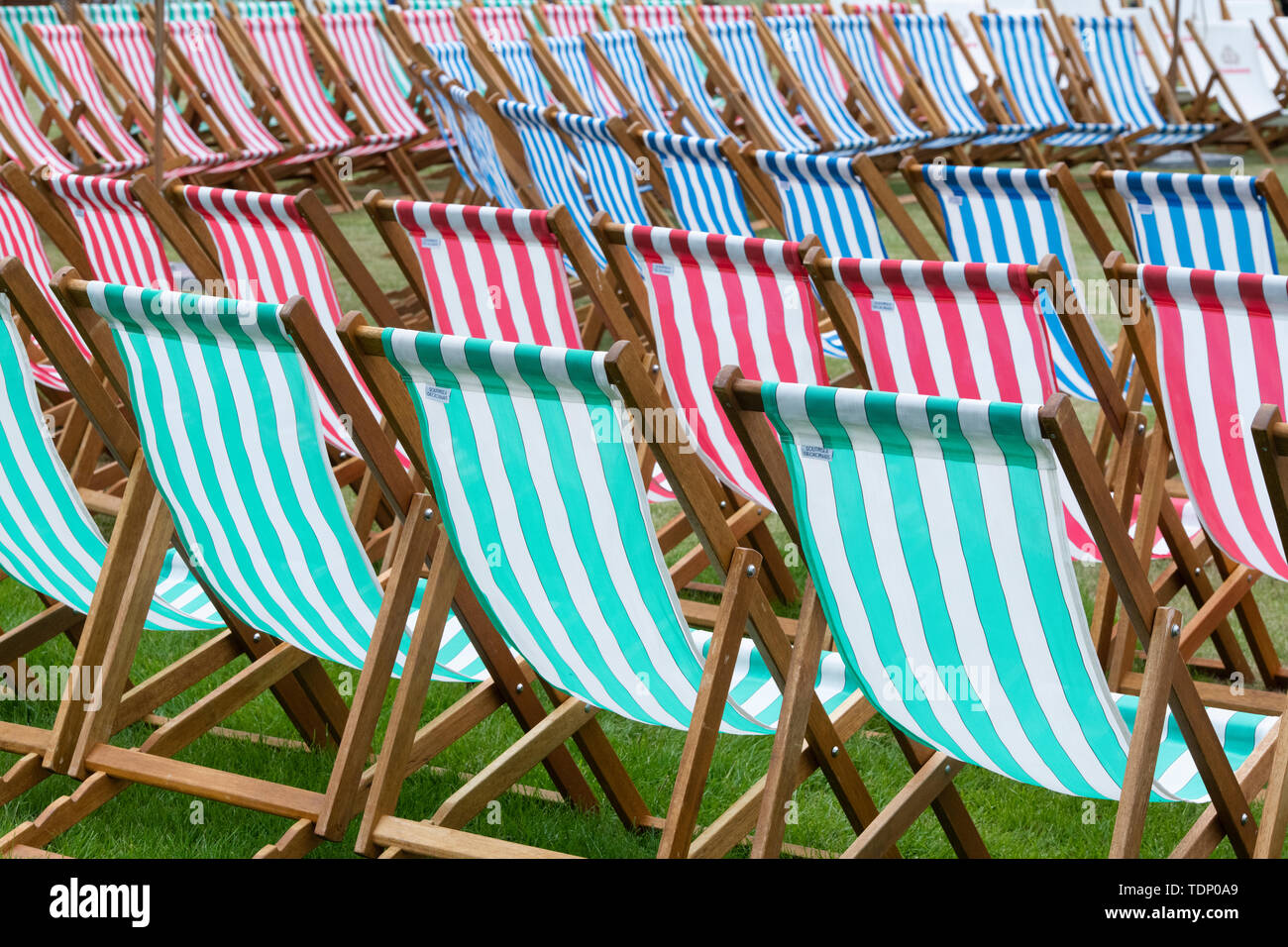 Bar rayé vert, rouge et bleu chaises longues à un flower show. UK Banque D'Images