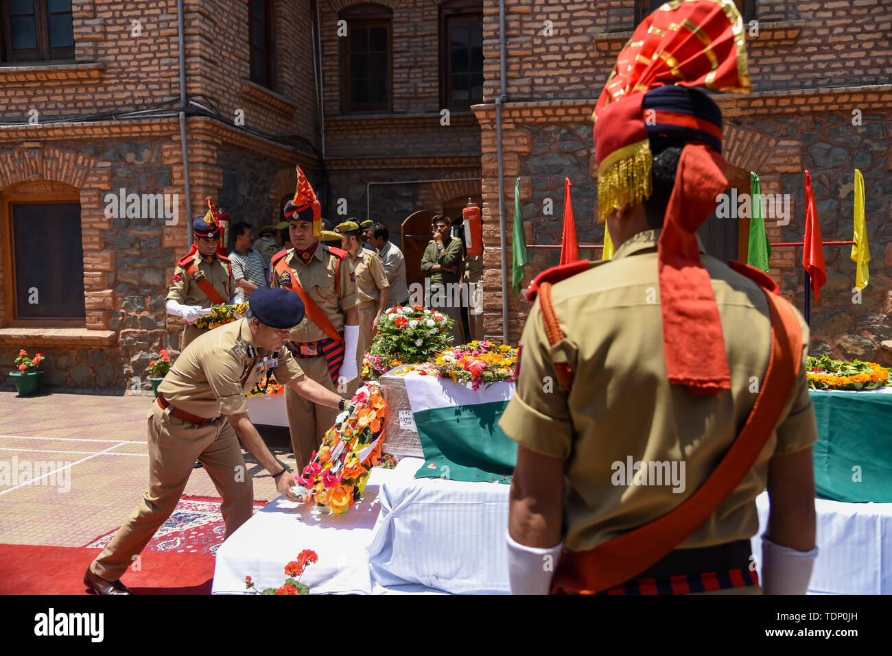 Un policier indien rend hommage à son collègue Arshad Khan lors de sa cérémonie de dépôt de gerbes à Srinagar. Agent de Station House, Arshad Khan qui a été grièvement blessé dans une attaque de militants le 12 juin, qui a également laissé cinq soldats paramilitaires indiens morts, a succombé de ses blessures dans un hôpital de New Delhi le dimanche. Banque D'Images