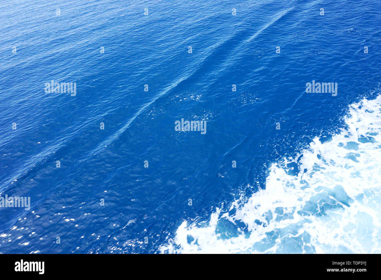 Abstrait d'arrière-plan. Surface en bleu clair. L'eau de mer avec une trace de diagonal white sea foam Banque D'Images