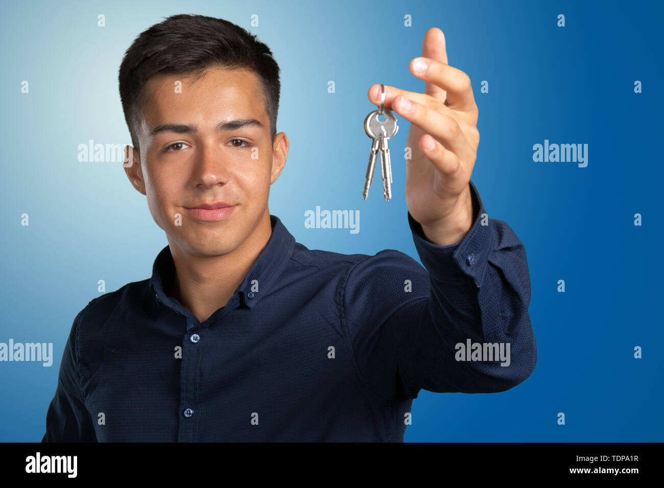 Jeune homme tenant les clés de la maison Banque D'Images