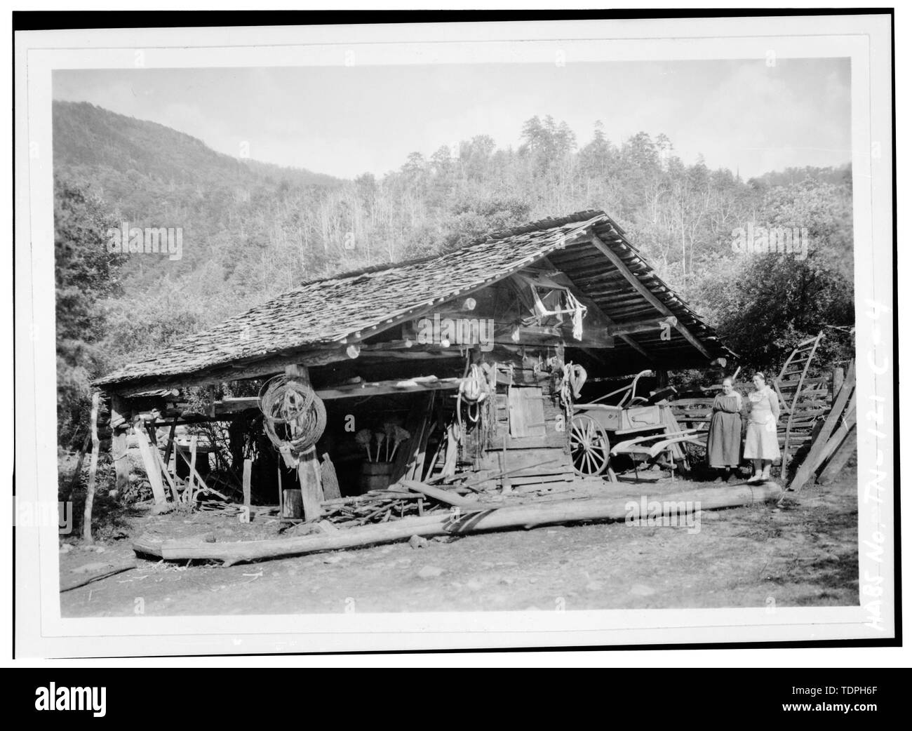 Montrant le berceau du maïs qu'elle en avait l'air le 21 mai 1936. Cette structure a également été utilisée comme un rapport de protection. Immédiatement à droite de la remise est non identifié, Hettie Walker et membre de la famille ou un ami. La photographie originale a été prise par Edouard E. Exline et est l'un des cinq photographies dans l'album, 'un croquis de la vie montagnarde- Great Smoky Mountains National Park", compilé par Edouard E. Exline et C.S. Grossman. L'album est dans le fichier le Great Smoky Mountains National Park ; la photographie est numéro II-B-(7)-8091. - Walker Family Farm, le maïs crèche, Gatlinburg, TN, Sevier Comté Banque D'Images