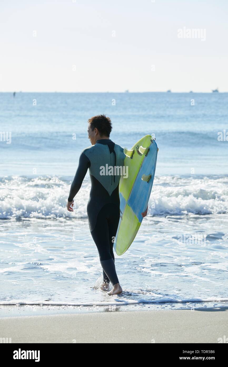 Surfeur japonais à la plage Banque D'Images